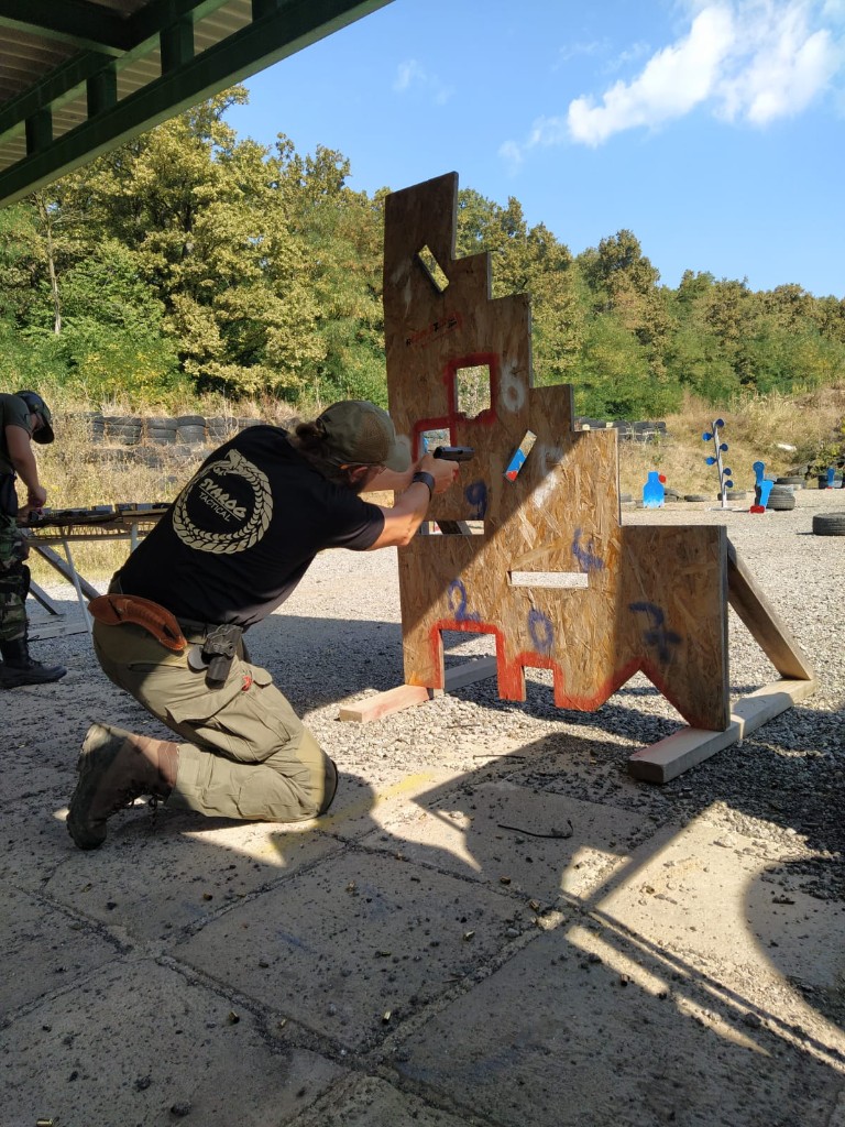 Skupina s pištoľami v formácii na krytej streľbe