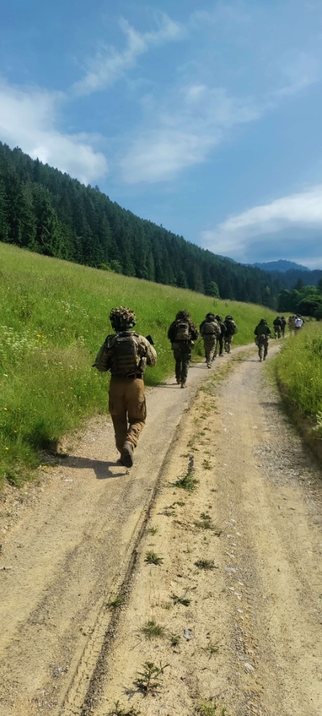 Účastníci v taktickom výstroji v zákope počas fieldcraft výcviku